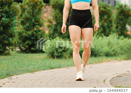Muscular legs of bodybuilder walking Muscular legs of bodybuilder walking 104994037