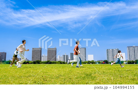 公園で駆けっこをする家族三世代 公園で駆けっこをする家族三世代 104994155