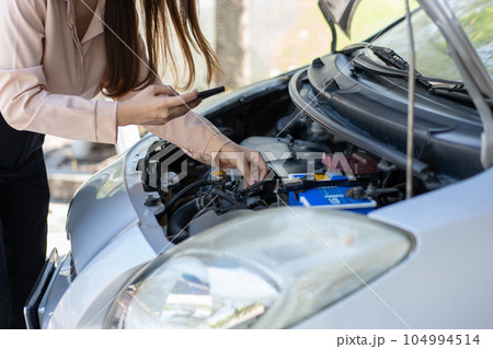Angry Asian woman using a smartphone VIDEO conference for assistance after a car breakdown on street. Concept of a vehicle engine problem or accident and emergency help from a Professional mechanic Angry Asian woman using a smartphone VIDEO conference for assistance after a car breakdown on street. Concept of a vehicle engine problem or accident and emergency help from a Professional mechanic 104994514