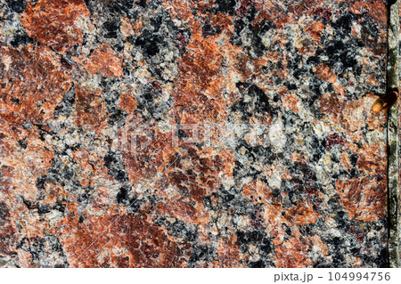 The texture of the stone surface is brown. 104994756