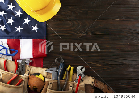 Tools hardhat toolbelt and us flag on wooden background labor day banner mockup 104995044