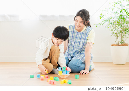ブロックで遊ぶ男の子と若い女性保育士 104996904