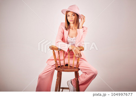 Fashion, portrait and serious woman on chair in studio isolated on a white background mockup space. Confident, stylish and female model from Brazil with cool designer clothes, pink hat and aesthetic. Fashion, portrait and serious woman on chair in studio isolated on a white background mockup space. Confident, stylish and female model from Brazil with cool designer clothes, pink hat and aesthetic. 104997677