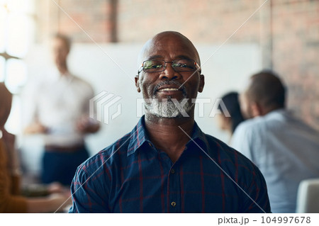 Mature business man sitting in a meeting, conference or seminar in a boardroom with colleagues at work. Closeup portrait of face of a senior, happy and corporate professional in a training workshop Mature business man sitting in a meeting, conference or seminar in a boardroom with colleagues at work. Closeup portrait of face of a senior, happy and corporate professional in a training workshop 104997678
