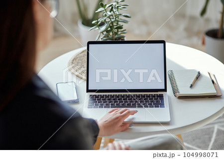 Mockup white screen laptop and mobile phone woman using computer sitting at table at home, back view Mockup white screen laptop and mobile phone woman using computer sitting at table at home, back view 104998071
