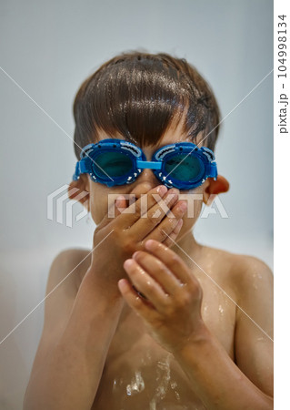 Child in diving goggles have fun while bathing in the bathroom 104998134