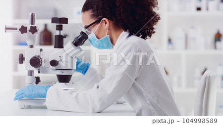 Microscope, healthcare and woman scientist in a lab for science, medicine and data analysis. Laboratory, science and female health expert checking medical results and working on a cure for cancer 104998589