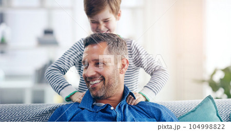 Love, father and son happy smile in living room of their home with lens flare. Happiness or caring, family and male parent with child playing spending quality time or bonding together on couch 104998822
