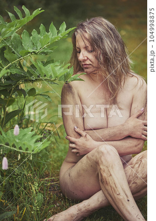 Naked beautiful dirty woman in the evening garden Naked beautiful dirty woman in the evening garden 104998875