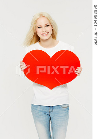 Red heart, love and portrait of woman in studio for peace, self love and affection on white background. Shape, emoji and face of girl holding cardboard sign, loving and gesture with mockup space Red heart, love and portrait of woman in studio for peace, self love and affection on white background. Shape, emoji and face of girl holding cardboard sign, loving and gesture with mockup space 104998890