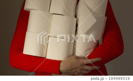 A woman holds rolls of paper in hands A woman holds rolls of paper in hands 104999319