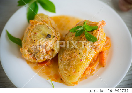 stewed in gravy stuffed peppers in a plate on a wooden table stewed in gravy stuffed peppers in a plate on a wooden table 104999737