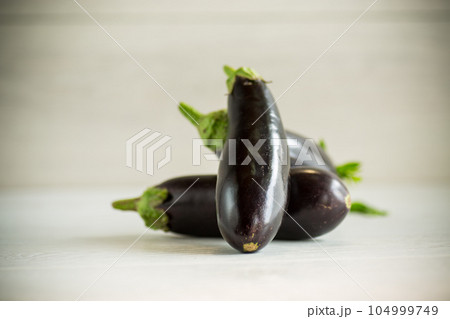 ripe purple eggplant on a wooden background 104999749