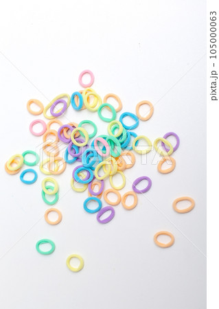 Many small multi-colored hair scrunchies on a pink pastel background Many small multi-colored hair scrunchies on a pink pastel background 105000063
