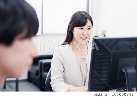 オフィスで笑顔で仕事をするオフィスワーカー オフィスで笑顔で仕事をするオフィスワーカー 105000843