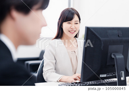 オフィスで笑顔で仕事をするオフィスワーカー オフィスで笑顔で仕事をするオフィスワーカー 105000845