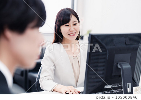 オフィスで笑顔で仕事をするオフィスワーカー オフィスで笑顔で仕事をするオフィスワーカー 105000846