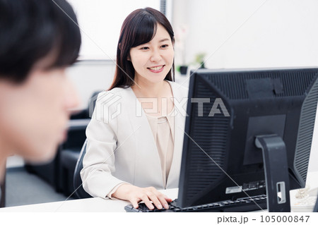 オフィスで笑顔で仕事をするオフィスワーカー オフィスで笑顔で仕事をするオフィスワーカー 105000847