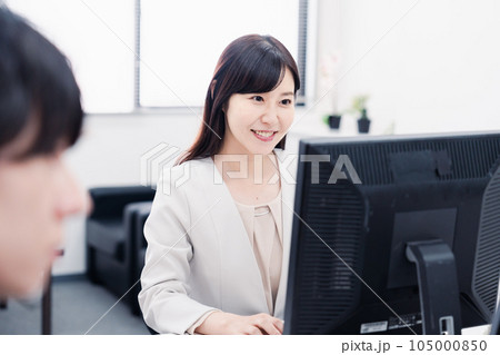 オフィスで笑顔で仕事をするオフィスワーカー オフィスで笑顔で仕事をするオフィスワーカー 105000850