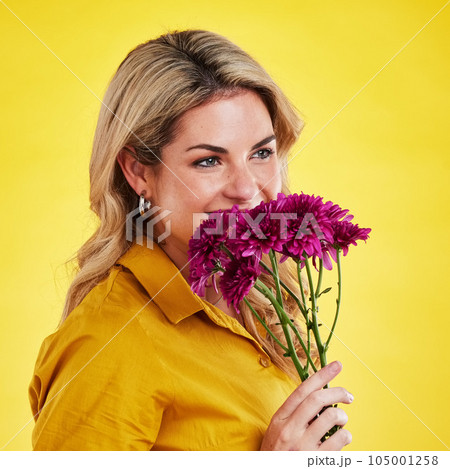 Portrait, smile and woman smelling flowers in studio isolated on a yellow background. Floral, bouquet and happiness of person sniffing or female model with scent of natural plants and dahlia aroma. 105001258