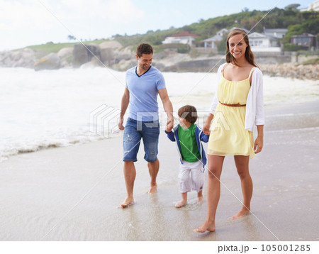 Family, portrait and holding hands while walking at beach for travel, fun or holiday in summer with a smile. Man, woman and child or son walk together on vacation at sea with happiness, love and care Family, portrait and holding hands while walking at beach for travel, fun or holiday in summer with a smile. Man, woman and child or son walk together on vacation at sea with happiness, love and care 105001285