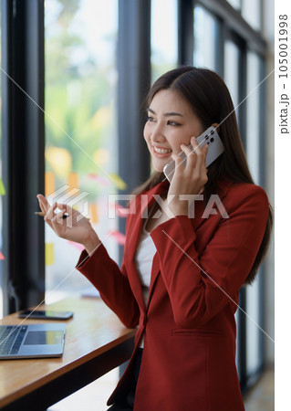 Consultant, advisor, Asian business woman working on the computer and using smartphone mobile talking work financial and marketing business planning company profits, marketing planning budget Consultant, advisor, Asian business woman working on the computer and using smartphone mobile talking work financial and marketing business planning company profits, marketing planning budget 105001998