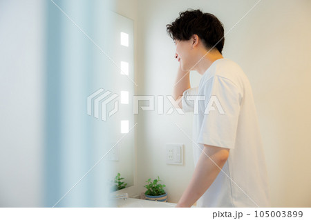 洗面所で鏡を見る男性 105003899