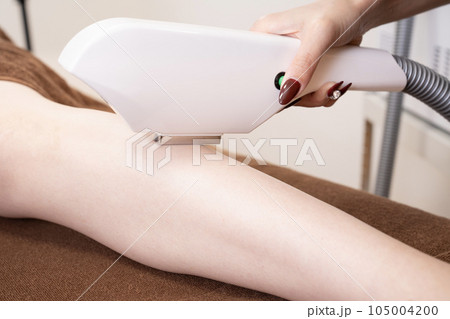 足の脱毛の施術をする女性の手元 105004200
