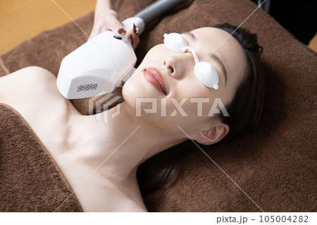 顔の脱毛の施術を受ける女性 105004282