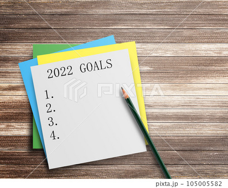 Writing note showing 2022 GOALS on wood table background. 105005582