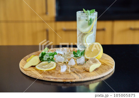 Organic cocktail drink with sparkling water lemon mint leaves ginger and ice Organic cocktail drink with sparkling water lemon mint leaves ginger and ice 105005875