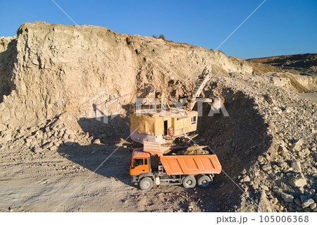 Aerial view of open pit mine of sandstone materials for construction industry with excavator loading dump truck with stones. Heavy equipment in mining and production of useful minerals concept Aerial view of open pit mine of sandstone materials for construction industry with excavator loading dump truck with stones. Heavy equipment in mining and production of useful minerals concept 105006368