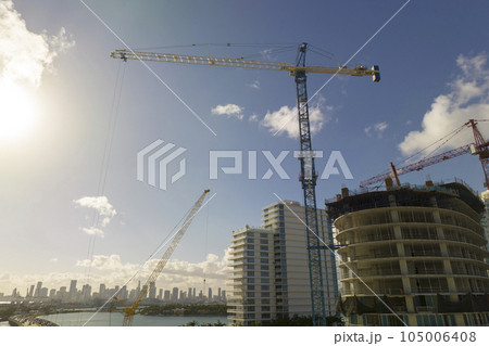 Aerial view of new developing residense in american urban area. Tower cranes at industrial construction site in Miami, Florida. Concept of housing growth in the USA 105006408