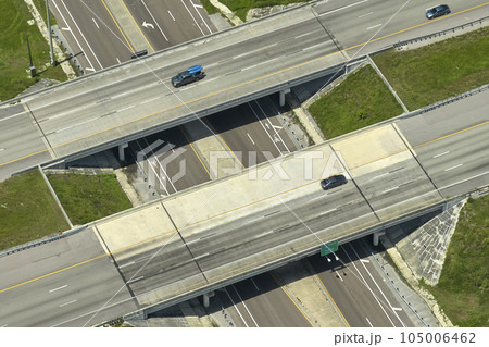 Aerial view of freeway overpass junction with fast moving traffic cars and trucks. Interstate transportation infrastructure in USA Aerial view of freeway overpass junction with fast moving traffic cars and trucks. Interstate transportation infrastructure in USA 105006462