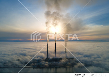 Aerial view of coal power plant high pipes with black smoke moving up polluting atmosphere at sunset Aerial view of coal power plant high pipes with black smoke moving up polluting atmosphere at sunset 105006520