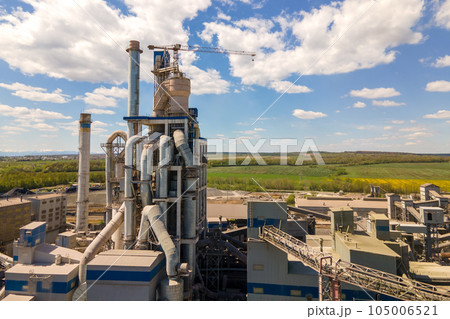Aerial view of cement plant with high concrete factory structure and tower crane at industrial production area. Manufacture and global industry concept. 105006521