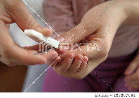 Mother use Nail Trimmer with baby hand. Mom cutting tiny fingernails. Baby care concept. How to successfully clip your baby's nails. Closeup. Newborn hygiene. Clipping Child's Nails. Front view. Mother use Nail Trimmer with baby hand. Mom cutting tiny fingernails. Baby care concept. How to successfully clip your baby's nails. Closeup. Newborn hygiene. Clipping Child's Nails. Front view. 105007095