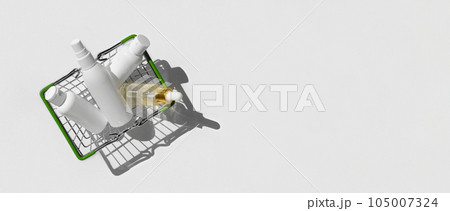 Shopping basket with cosmetics on a white background. Blank plastic jars, bottles. Online home shopping. Purchase of beauty and health care products. Gifts to woman in mini shopping trolley. Sale 105007324