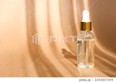 Natural oil cosmetics on neutral background. Dropper glass Bottle Mock-Up. Oily cosmetic pipette. Face and body treatment. Spa concept. 105007344