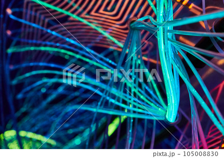 Crisscrossing web of colorful LED techno neon lights of orange and sky blue Crisscrossing web of colorful LED techno neon lights of orange and sky blue 105008830
