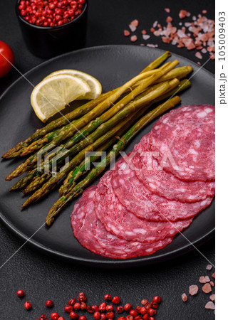 Delicious nutritious breakfast consisting of sliced sausage, asparagus, salt, spices and herbs Delicious nutritious breakfast consisting of sliced sausage, asparagus, salt, spices and herbs 105009403