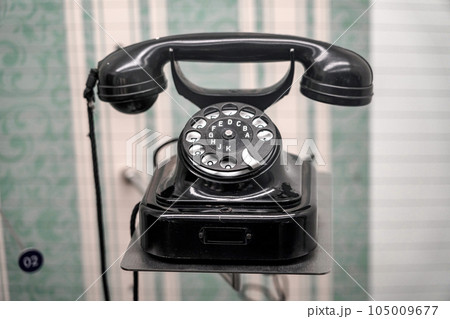 An old corded rotary telephone in a museum display case. 105009677