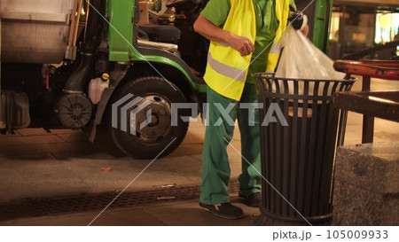Unknown street janitor or garbage man at work the centre of Milan in the evening, Italy 105009933