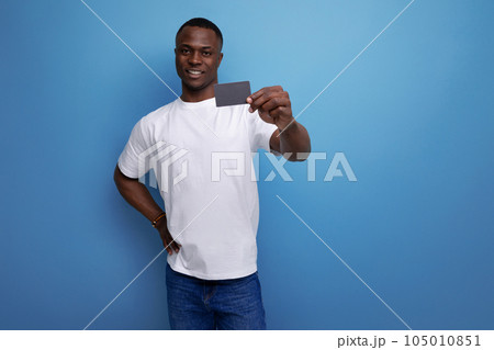 casual 30s african man with short haircut in white t-shirt showing plastic card mockup 105010851