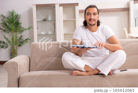 Young man doing physical exercises at home Young man doing physical exercises at home 105012065