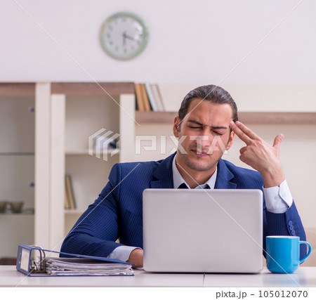 Young male employee working from home in pandemic concept 105012070