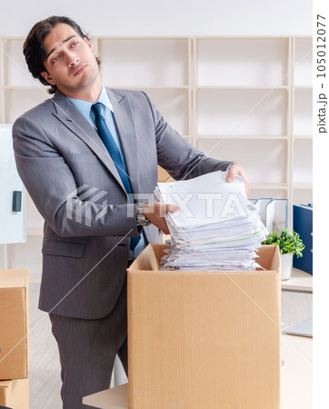 Young man employee with boxes in the office Young man employee with boxes in the office 105012077