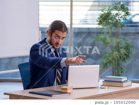 Young male teacher in suit in the classroom Young male teacher in suit in the classroom 105012090