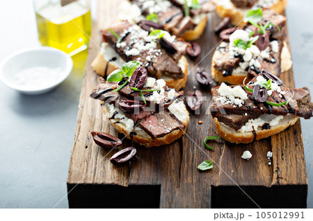Steak bruschetta with feta and olives Steak bruschetta with feta and olives 105012991