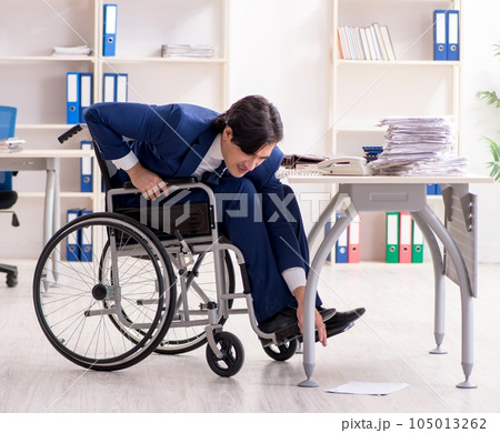 Young male employee in wheelchair working in the office Young male employee in wheelchair working in the office 105013262